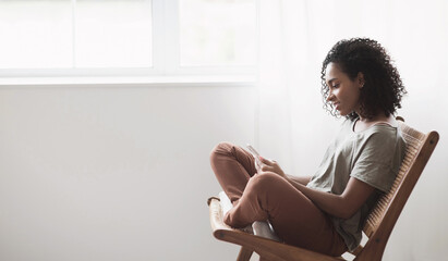 Sticker - Young woman using smartphone at home. Student girl texting on mobile phone in her room. Communication, home work or study, connection, mobile apps, technology, lifestyle concept