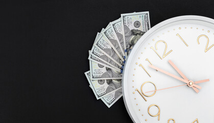 Wall Mural - Money with white clock on black background. Top view. Space for text.