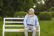 © Studio Romantic - Happy carefree senior caucasian man with smile on face sitting on wooden bench relaxing on sunny day in park feeling enjoyment. Good emotion and positive expression. Retirement concept