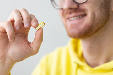 Smiling man takes a pill. Closeup. Healthcare and medicine.