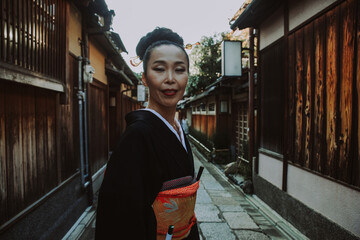 Wall Mural - Beautiful japanese senior woman walking in the village. Typical japanese traditional lifestyle