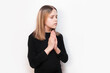 A young girl with a sad, pleading face holds her hands in front of her and prays, talks to God, to herself, her eyes closed. The concept of prayer, peace