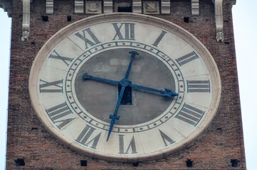 Wall Mural - Big tower clock at bell tower of old church in downtown Verona, Italy.