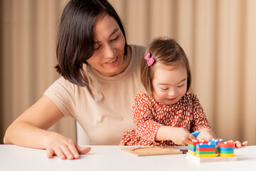 child girl with down syndrome learns with educational toys, inclusive education for children of different ages