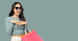 © Nutlegal - Shopping young woman wear sunglasses and holding shopping bags Young lady enjoy shopping and sales Look at copy space Beautiful asian girl get cheerful Smile face Pastel green background copy space