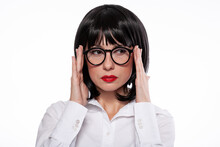 Black Haired Woman In Black Eyeglasses With Red Lips Wearing White Shirt Showing Emotions Of Suspicion Or Headache.