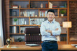 © Liubomir - Portrait of a successful businessman working in a classic office, Asian smiling and happy looking at camera with arms crossed
