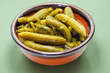 Small pickled cucumbers in brine according to a traditional recipe, served in a ceramic bowl