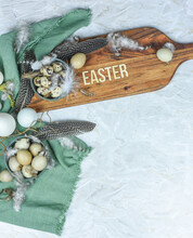 Ostern Dekoration Mit Eiern, Federn, Tulpen Und Traubenhyazinthen Auf Holzbrett Mit Schriftzug "Easter" Aus Holzbuchstaben