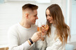 © Татьяна Волкова - Young beautiful couple at home celebrates date of acquaintance, drinks wine from glass glasses. Romantic relationships. Love and tenderness. Beauty and youth.