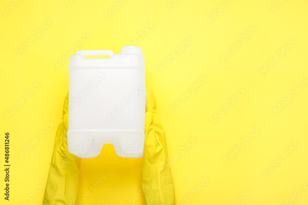 Female hands in rubber gloves with canister on color background