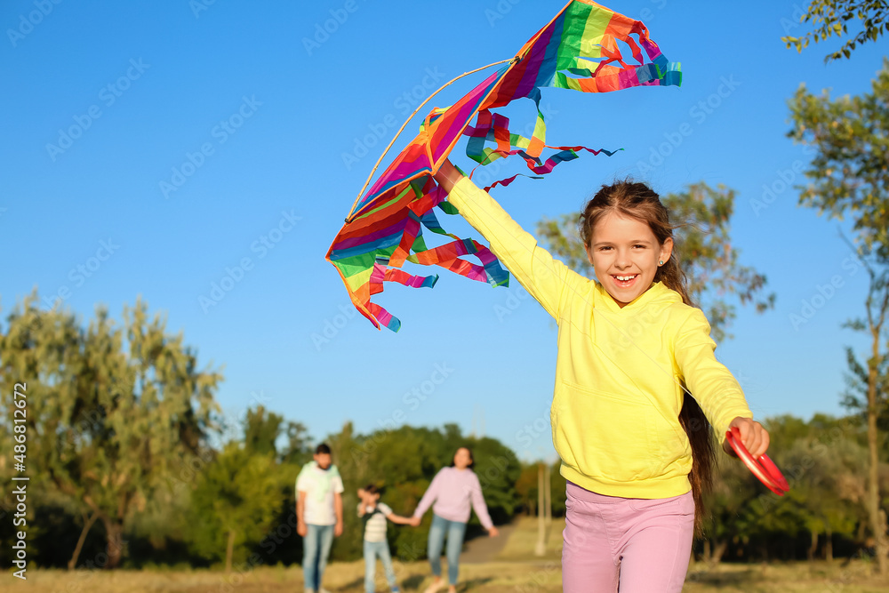 Happy little girl with kite in park