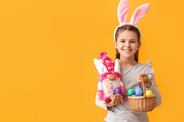 Poster - Funny little girl with bunny ears, toy and Easter eggs on color background