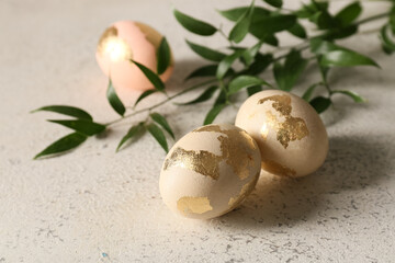 Wall Mural - Beautiful Easter eggs and plant branch on light background, closeup