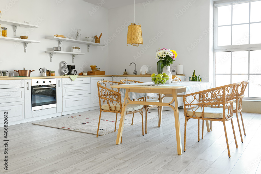 Interior of modern kitchen with dining table and beautiful Chrysanthemum flowers
