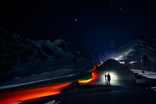 Man With Ski Near Yurt Nomadic House At Night At Mountains