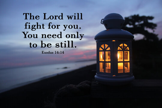 Wall Mural -  - Bible verse inspirational quote - The Lord will fight for you. You need only to be still. Exodus 14:14 With white lantern and candle light inside in the night after sunset in the beach.