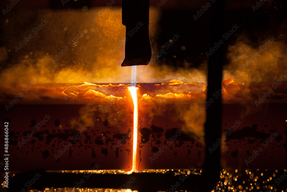Manufacturing of mild steel square bar with continuous casting machine. Cutting bars by gas torch, close-up photo. 