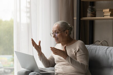 Happy Excited Elderly Grandma Woman Talking To Family On Video Call, Using Laptop. Mature Coach, Teacher Holding Online Class, Virtual Lesson, Speaking On Chat, Smiling At Screen, Gesturing With Hands