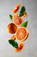 Bloody Orange Levitation. Oranges Slices In The Aer With Green Leaves. Abstract Citrus Fruit Composition.