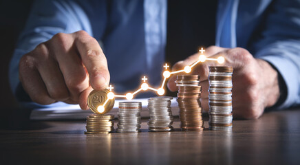 Wall Mural - Man stacking coins with a graph of profit.