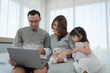 © plo - Asian Pregnant Family With Young Daughte Watching Cartoon From Computer Together in Bedroom