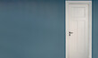 White door closed on blue wall background. Interior retro black metal doorknob and key lock