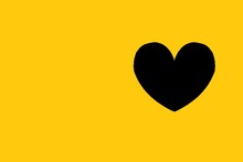 Black Heart With On Yellow Background. Copy Space