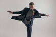 © Viorel Sima - elegant young guy in suit with long coat holding leg up and kicking