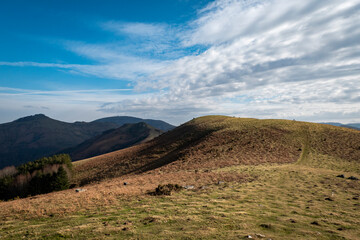 Vista sobre a montanha em Ainhoa com uma trilha e alguns turistas ao fundo no País Basco, França