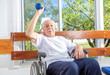 © jovannig - Caucasian senior on the wheelchair smiling at the gym. Retired elderly people living their life at its best.
