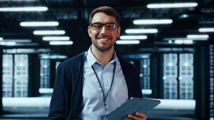 Fototapete - Portrait of a Bearded Handsome Caucasian IT Engineer in Glasses Standing with Tablet and Posing in the Middle of a Working Data Center Server Room with Server Computers Working on a Rack.