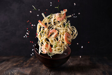 Fettuccine and prawns, levitating pasta with shrimps and spices.