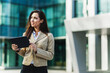 © milanmarkovic78 - Business Woman Holding Digital Tablet And Standing Outside An Office