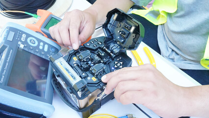 Technician Fiberoptic Fusion Splicing. Worker connecting for Cable Internet signal and Wire connection with Fiber Optic Fusion Splicing machine,fiber optic cable splice machine in work