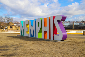 Wall Mural - a gorgeous shot of the colorful Memphis sign with gorgeous blue sky and powerful clouds with yellow winter grass at Mud Island Park in Memphis Tennessee USA 