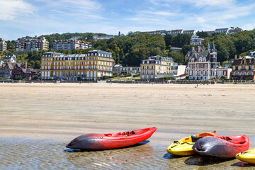 Wall Mural - Panoramic view of Trouville coastline with luxury buildings along the sandy beach. Colourful kayaks in the foreground. Normandy, France.