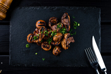 Wall Mural - grilled mushrooms on a black stone