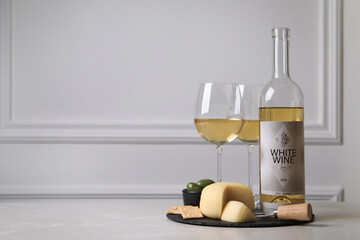 Poster - Bottle of white wine, glasses and crackers with cheese on table, space for text