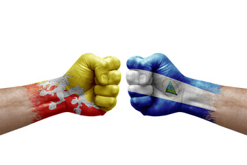 Two hands punch to each others on white background. Country flags painted fists, conflict crisis concept between bhutan and nicaragua