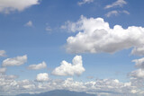 Fototapeta Na sufit - Bright blue sky with fluffy white clouds and mountains