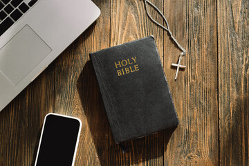 Study Bible worship online concept. Church online Sunday new normal concept. Bible, cell phone and earbuds on a wood background. Home church during quarantine coronavirus