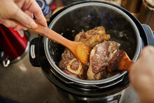 Ossobuco With Spindle Beef Is Fried In Pressure Cooker And Mixed With Wooden Spatulas. French Gourmet Cuisine