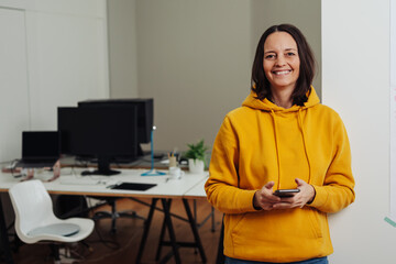 Smiling businesswoman in a casual yellow hoodie