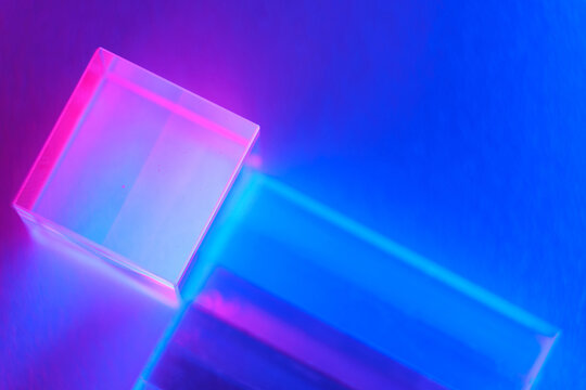 Neon background with geometric shapes. Luminous glass objects with multi-colored lighting, soft selective focus, copy space.