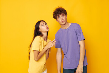 cute young couple in colorful t-shirts posing friendship fun yellow background unaltered