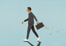 Businessman Walking With Money Falling Out Of Briefcase
