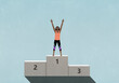 © fStop - Victorious female athlete standing with arms raised, celebrating on 1st Place podium