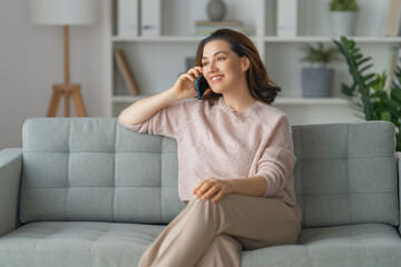 Poster - woman is using a phone sitting on a sofa