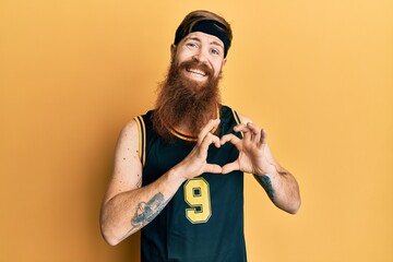 Sticker - Redhead man with long beard wearing basketball uniform smiling in love doing heart symbol shape with hands. romantic concept.